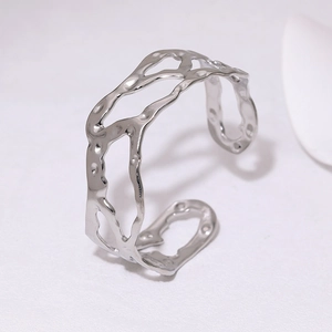 Detailed view of silver stainless steel cuff with hammered texture and hollow design