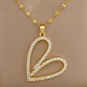 Close-up of golden heart pendant with shimmering crystals on a sleek lip chain