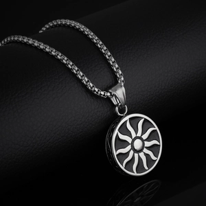 Silver stainless steel sun pendant necklace with box chain on a black textured background