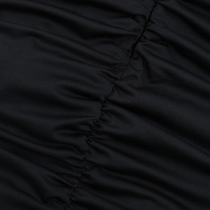 Détail macro du tissu froncé noir avec un éclat soyeux sur une robe courte ajustée