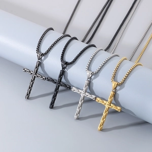 Detailed view of four cross pendants with bamboo texture in gold, silver and black finish