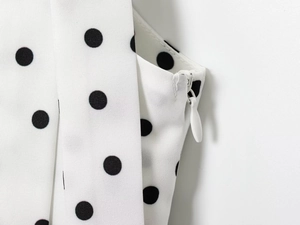 Détail de la fermeture éclair invisible blanche et du tissu sur une robe à pois