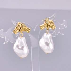 Close-up of elegant gold woven knots and baroque pearls on a heart-shaped stand