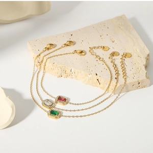 Close-up of 18K gold plated titanium steel bracelets with red, white and green zircon stones