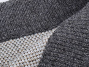 Macro view of grey rib-knit collar and multicolored jacquard fabric with soft texture