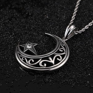 Macro d'un pendentif lune et étoile en acier titane argenté avec une pierre précieuse
