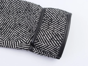 Detail of herringbone tweed cuff with premium black leather piping and textured wool fabric