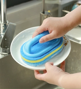 Kitchen sponge cleaning brush with handle scrubbing a white plate in a sink