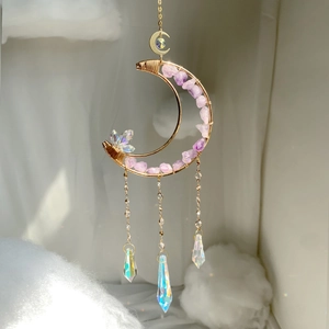 Detail of golden crescent moon suncatcher with purple amethyst stones and crystal prisms