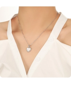 Detail of S925 sterling silver heart necklace with white opal stone worn by a model
