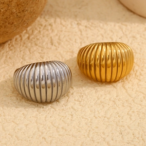 Bagues croissant polies en or 18 carats et argent sur fond de pierre texturée minimaliste