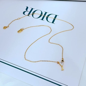 Detail of gold cocktail glass necklace with zircon inlay and heart tail pendant