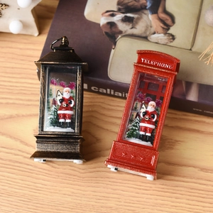 Close-up of vintage lantern and red telephone booth with Santa Claus and snow scenery