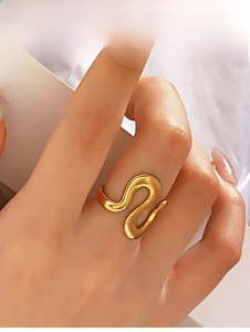 Macro detail of wave-shaped golden irregular ring with polished finish on model's hand