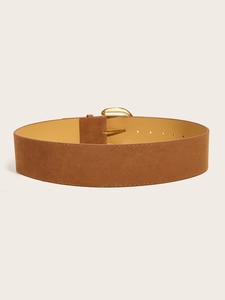 Detail of a brown suede wide waist belt with a semi-circular gold metal buckle on top