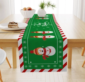 Detailed view of a green Christmas table runner with snowman and snowflake patterns