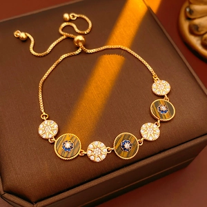 Detail of vintage gold bracelet with tiger eye stone and starburst zircon charms