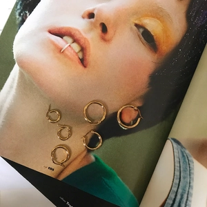 Detailed set of six polished gold hoop earrings in various sizes on a stylish background