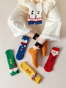 Close-up of fluffy coral fleece Christmas socks featuring festive holiday patterns and colors