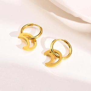 Detail of golden stainless steel hoop earrings with a polished crescent moon pendant charm
