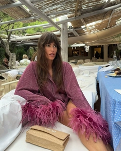 Détail d'une chemise rose scintillante avec poignets en plumes pour un style de vacances