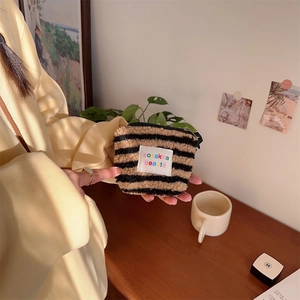 Close-up of brown and black striped plush mini pouch with a branded sozakka label