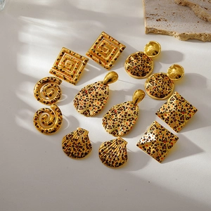 Macro view of assorted leopard print earrings featuring 18k gold geometric designs