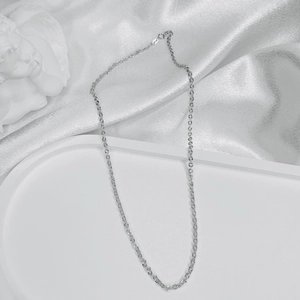 Close-up of S925 sterling silver chain on white satin background with artistic props