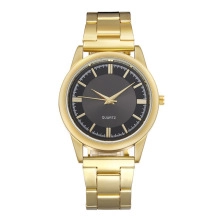 Detailed close-up of a gold mesh band watch with a black dial and quartz movement