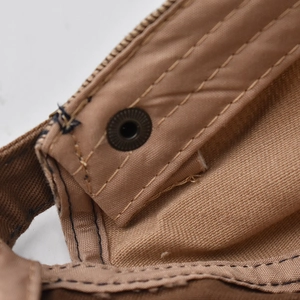Macro detail of retro cotton beret showing durable stitching and bronze metal eyelet