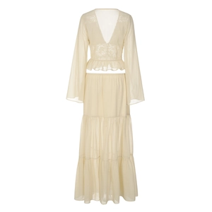 Close-up of beige lace chiffon cardigan and tiered ruffle skirt with boho flare