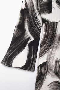 Detail of elegant black and white brushstroke print on lightweight long sleeve fabric