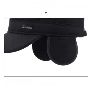 Detail of warm winter flat cap for men with earflaps and JEANS embroidery