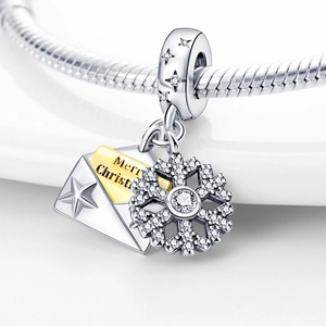Macro shot of silver and gold envelope charm with snowflake and zircon accents