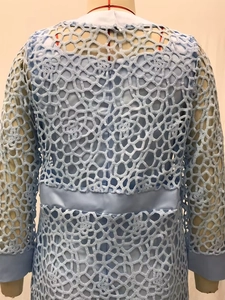 Vue détaillée du tissu en dentelle bleu clair avec des motifs géométriques ajourés complexes