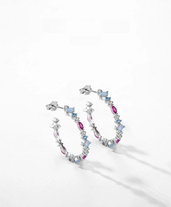 Detail of S925 silver hoop earrings with oval pink and round blue zircon gemstones