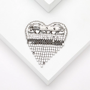 Detail view of the silver heart brooch back showing pin clasp and fringe chain structure