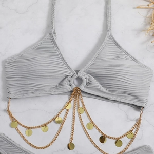 Detail of light gray ribbed bikini top featuring decorative gold chains and a metal ring