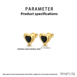 Macro detail of gold stainless steel heart stud earrings with black enamel inlay