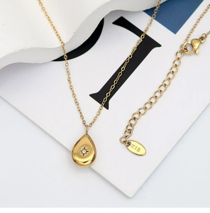 Dettaglio della collana a goccia placcata oro 18K con incastonatura a stella e marchio K18
