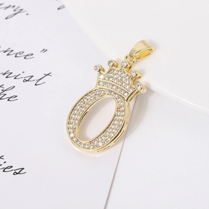 Macro shot of gold-plated crown number zero pendant with sparkling clear zircons