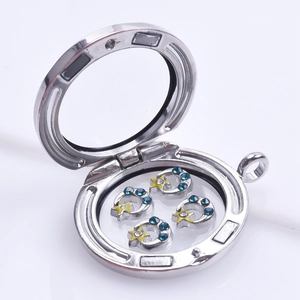 Detail view of open silver round locket with moon and star floating charms