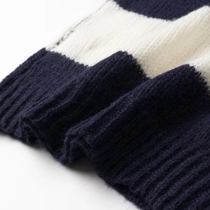 Close-up of soft navy blue and white striped knit fabric with ribbed cuff detail