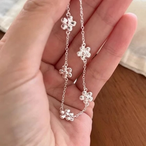 S925 sterling silver bracelet featuring five delicate five-petal flower charms on a thin chain