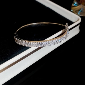 Detailed view of silver oval bangle with pavé zircons on black velvet background