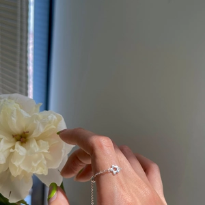 Close-up of adjustable 925 silver chain ring featuring a delicate hollow flower charm