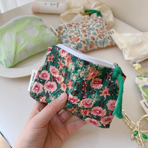 Gros plan de mini pochettes plissées à fleurs avec étiquette et cordon de serrage vert