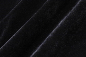 Detalle macro de la textura de la tela de terciopelo negro que muestra brillo y tejido fino