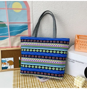 Detail of blue canvas tote bag with ethnic geometric patterns and grey handles