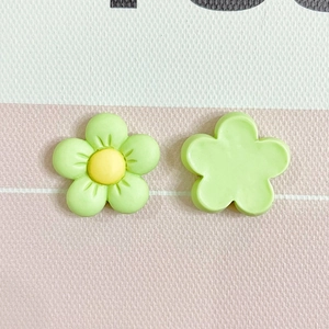 Macro detail of matte green five-petal resin flower charms with yellow center buds